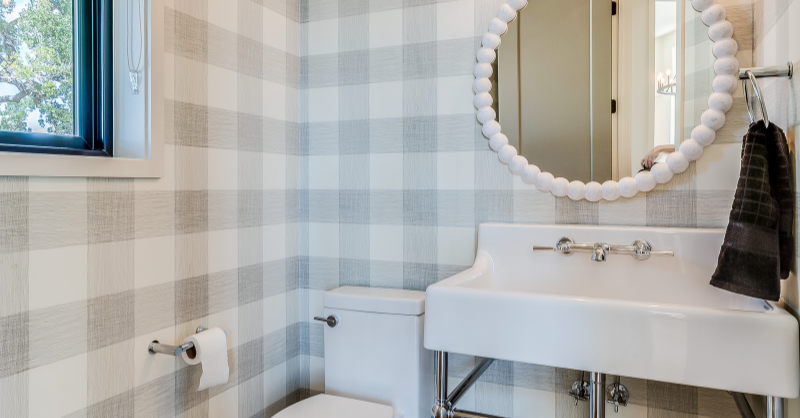 Light gray plaid wallpaper in a bathroom with white fixtures.