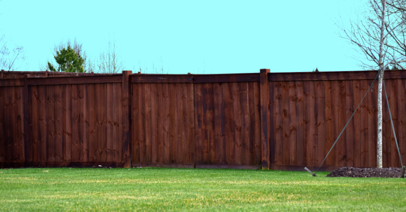 Wood fence stained a dark brown shade in Omaha, NE.