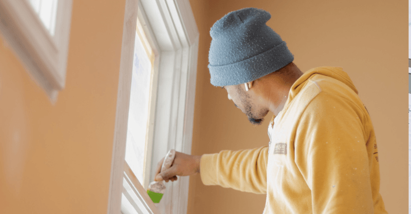 Brush & Roll painting employee painting window trim white.
