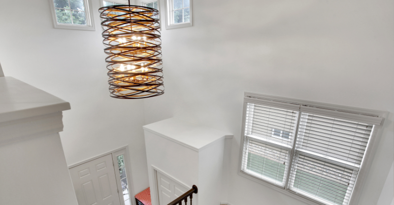 entryway and staircase with large white walls and windows.
