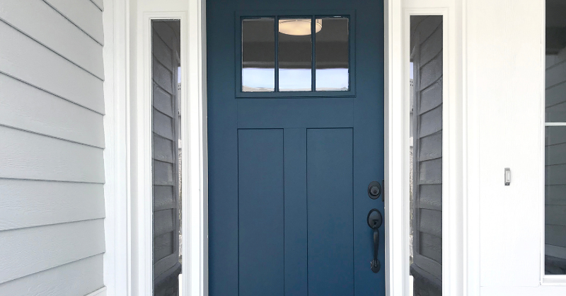 Exterior front door painted a darker blue with windows near the top.
