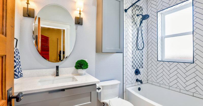 Small bathroom with light white/grey walls and grey bathroom vanity.