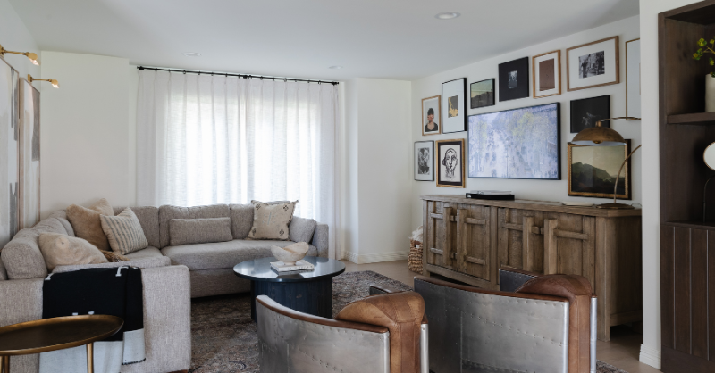 Living room in home with white walls and ceilings and neutral furniture.