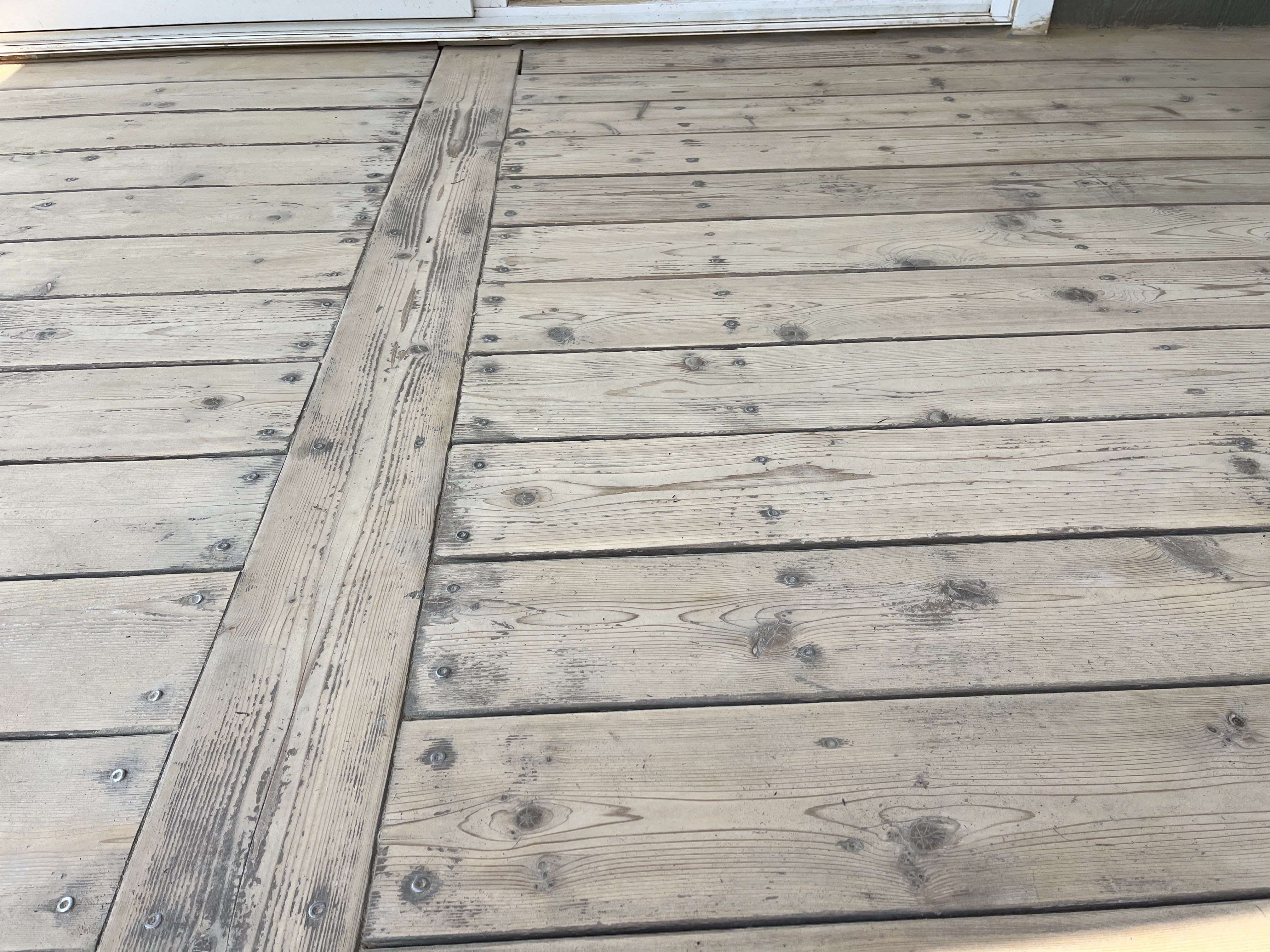 Wood boards on a deck that have been sanded with a power sander.