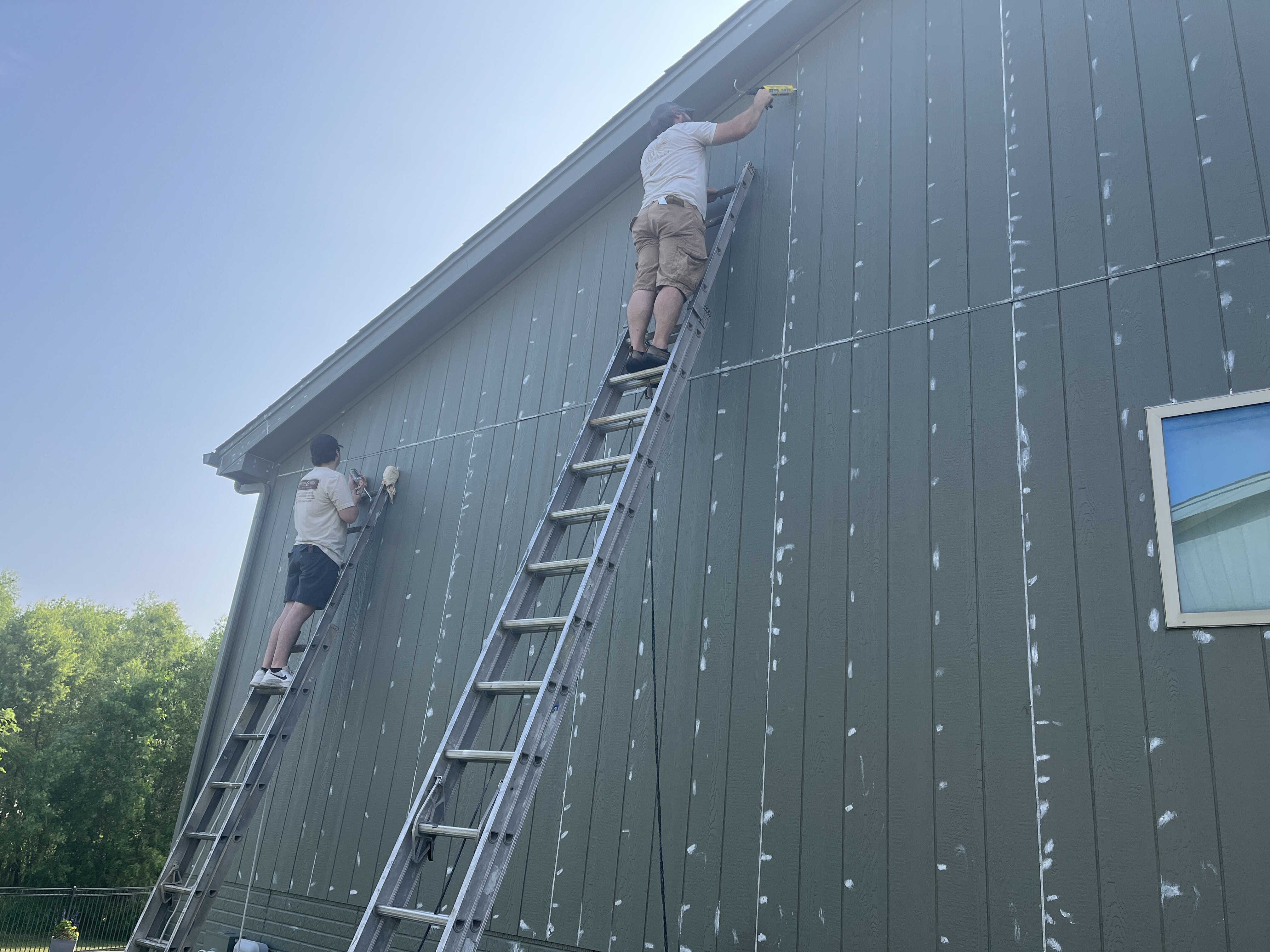 Brush & Roll Painting Painters in Omaha caulking exterior of home.