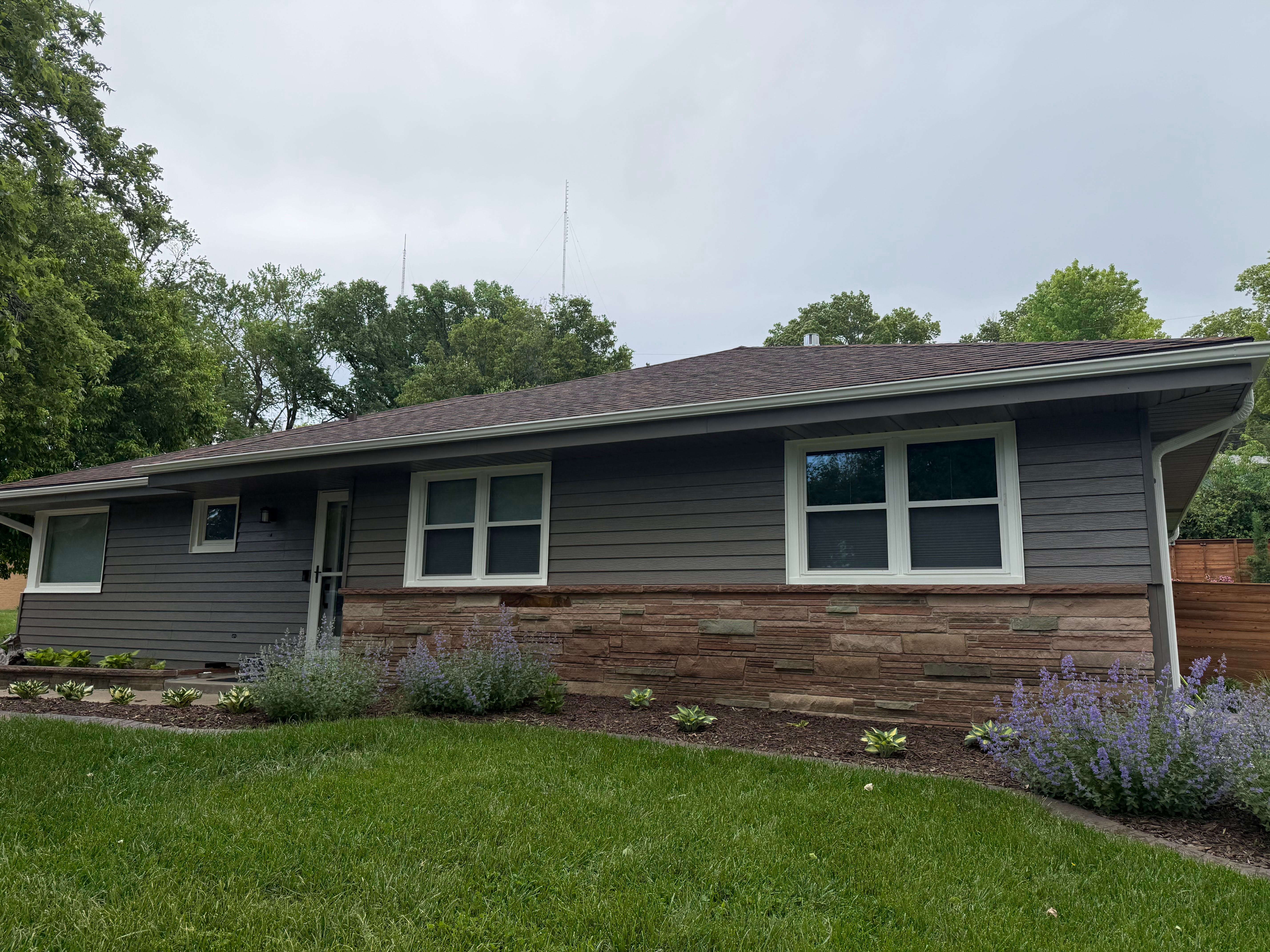 Exterior of a house painted off grey color to match roof, with white trim.