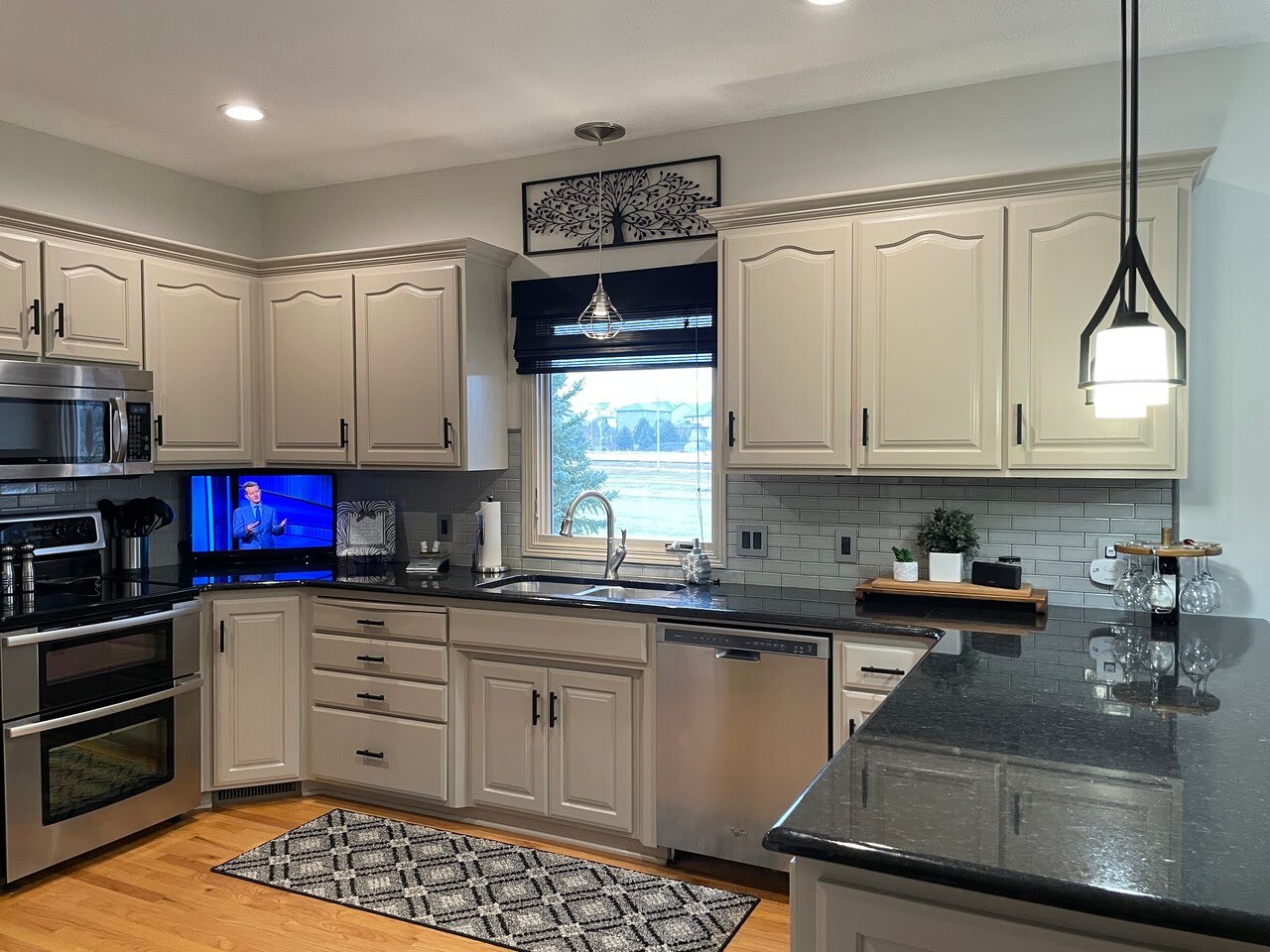 Kitchen with cream painted cabinets, black counters, and dark hardware.