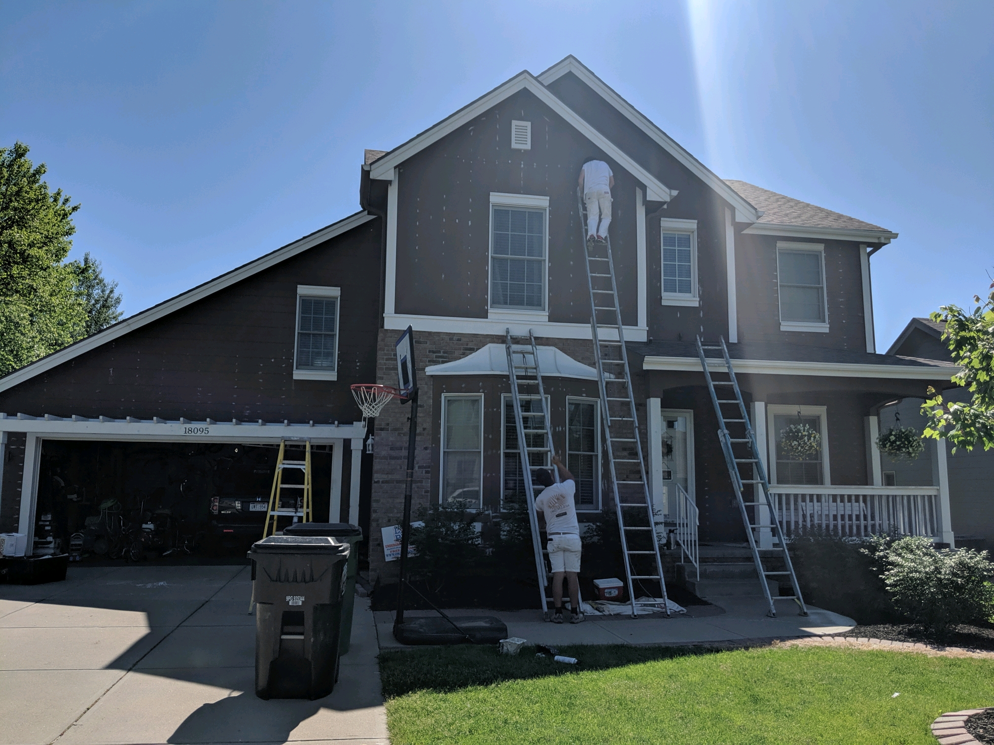 Painters prepping exterior of home before painting.